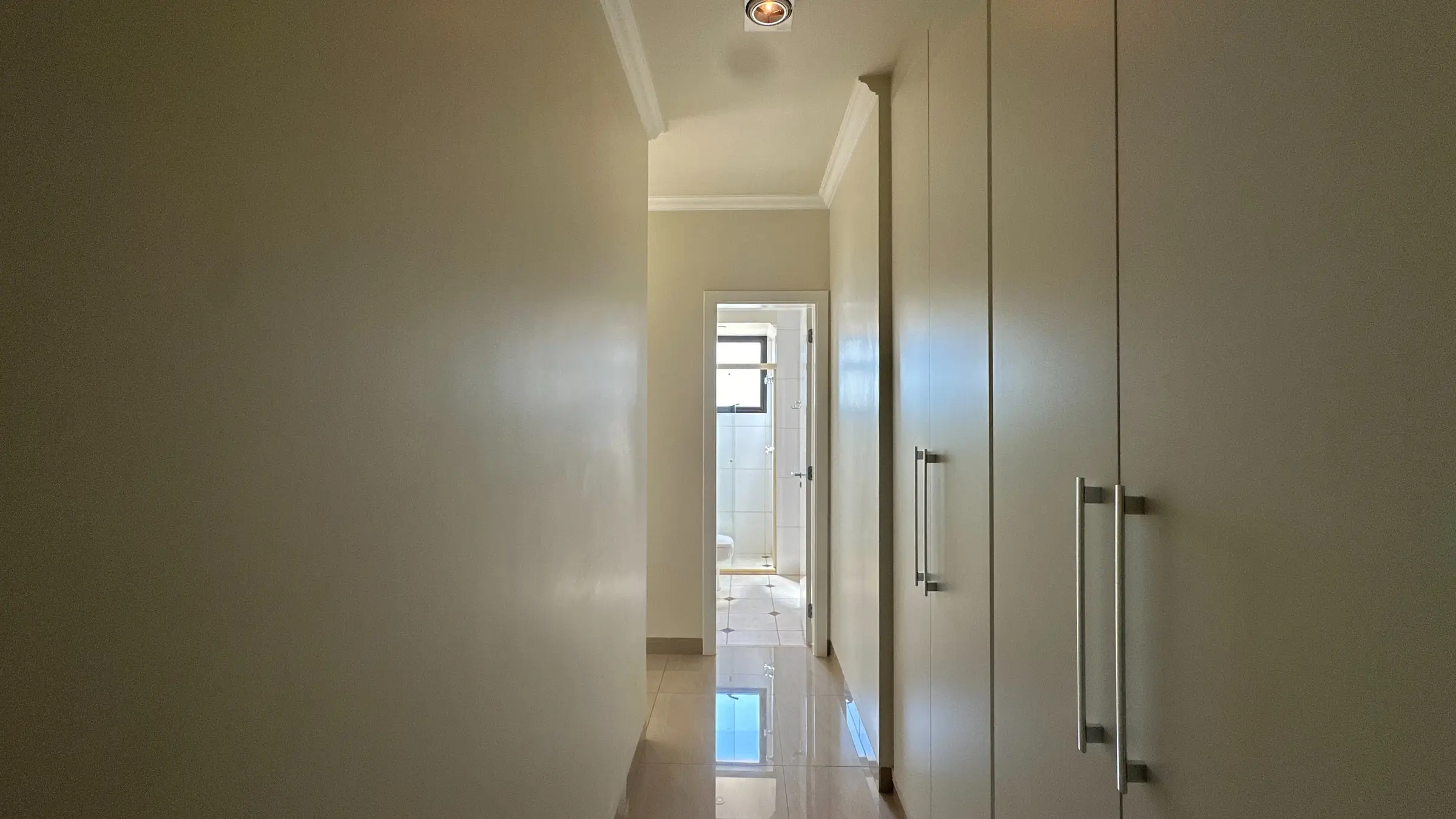 Corredor interno do apartamento no Jardim Irajá, com portas e marcenaria ao longo da parede